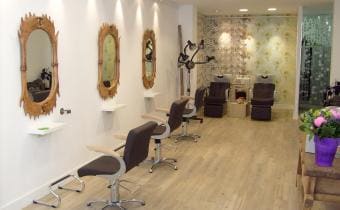 Het interieur van de salon aan de Hogewoerd, met kappersstoelen en spiegels.